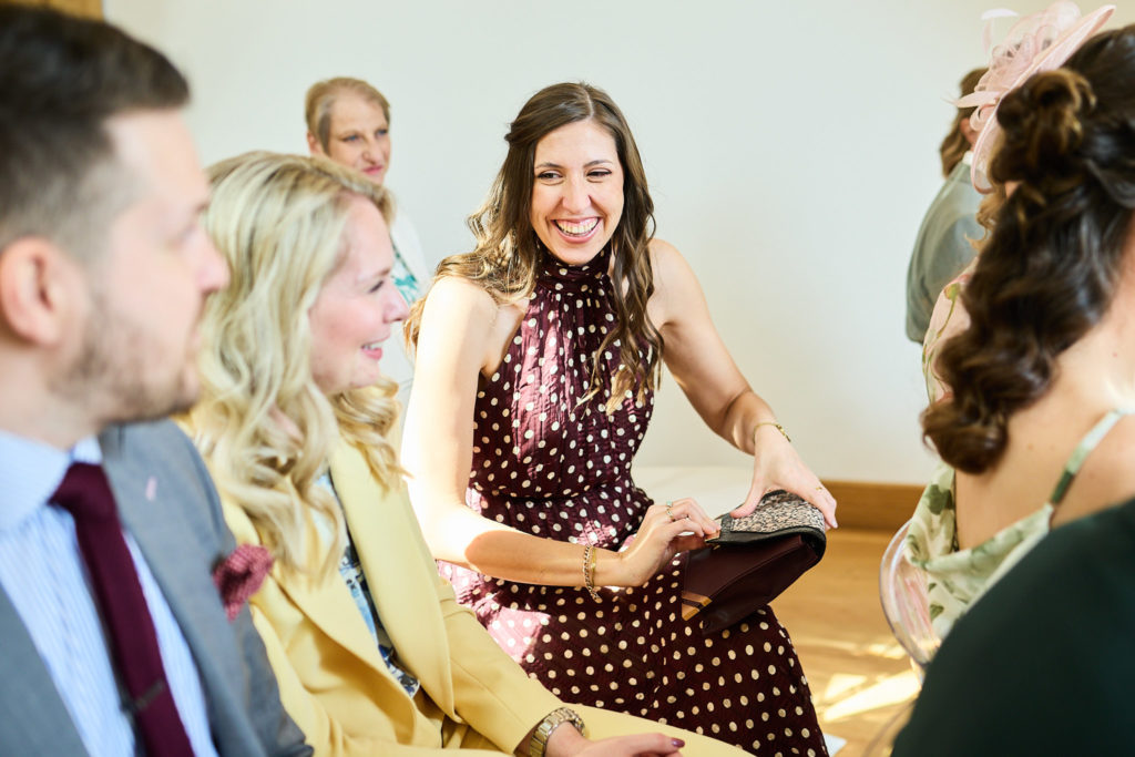 Wedding guests laughing in their seats during the ceremony