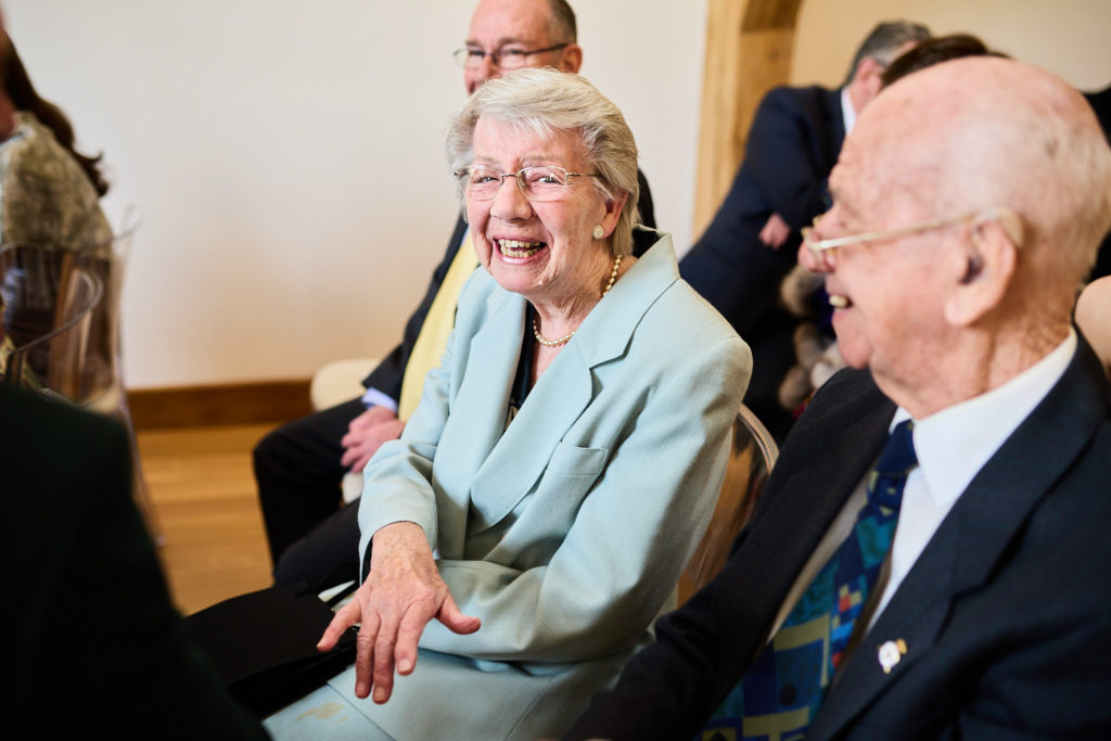 Two elderly wedding guests laughing together