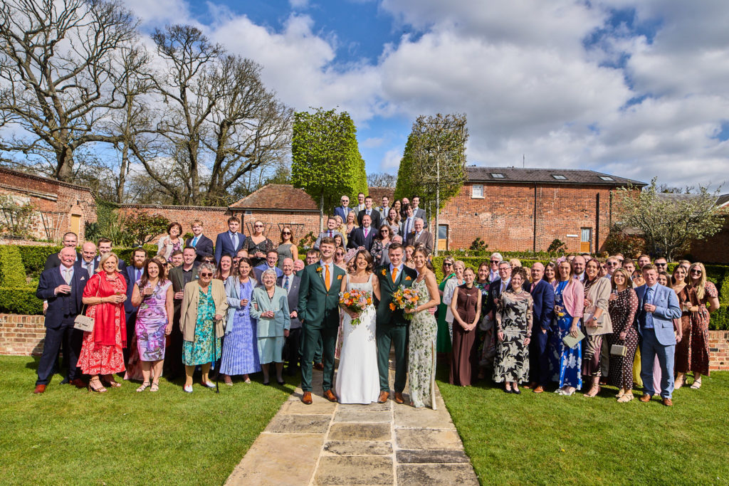 Group photo of all the wedding guests in the walled garden at Hatfield Place