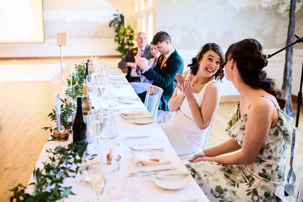 Bride laughing at the top table during the speeches