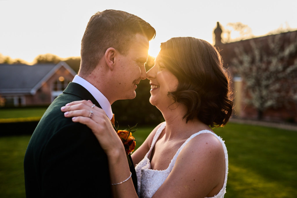 Bride and groom nose to nose at sunset at Hatfield Place