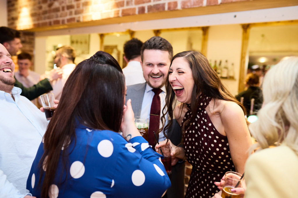 Wedding guests laughing together at the reception