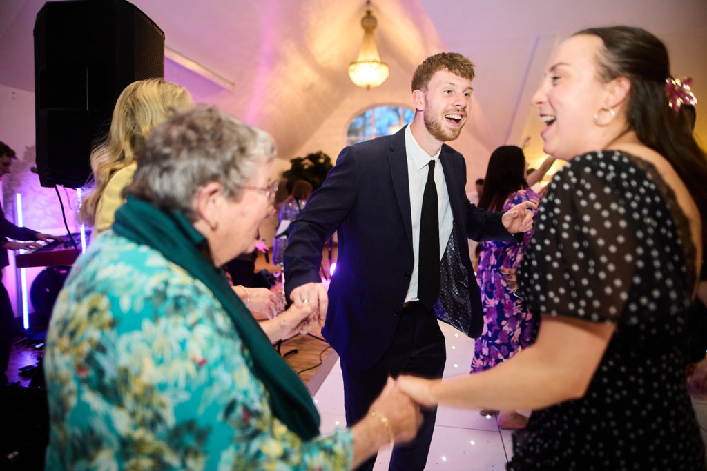 Wedding guests dancing hand in hand