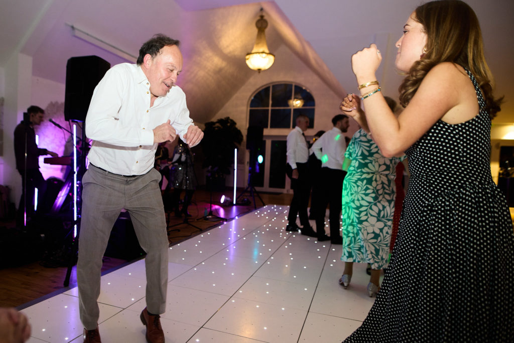 Wedding guests dancing on a white dance floor