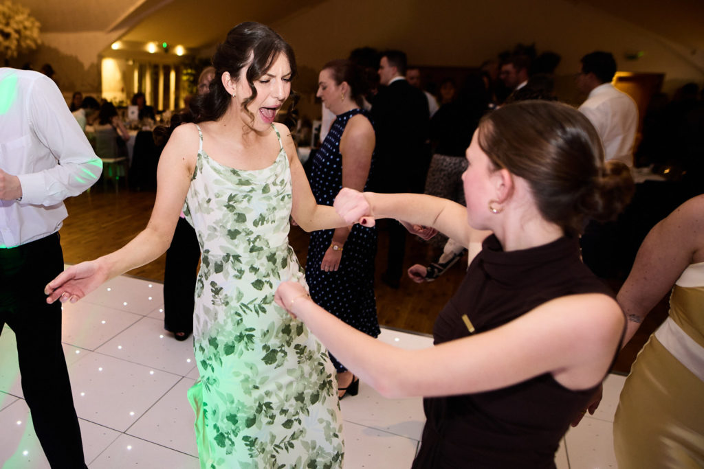 Wedding guests dancing hand in hand on the dance floor