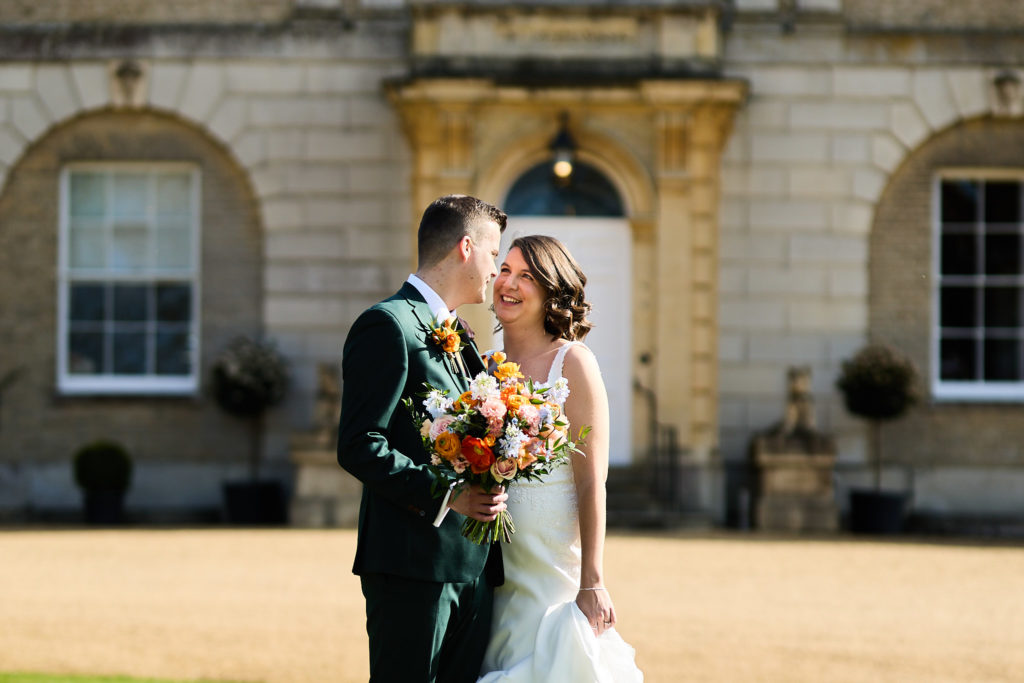 Bride and groom kissing in front of Hatfield Place