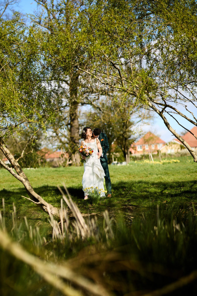 Bride and groom embracing among the trees at Hatfield Place