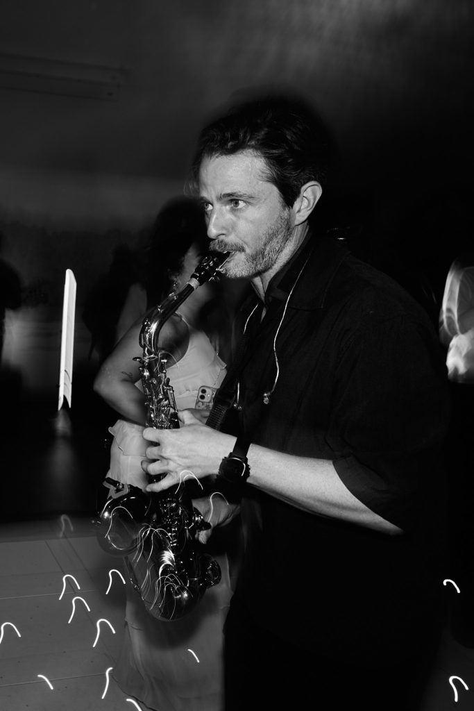 Black and white photo of the saxophonist playing on the dance floor