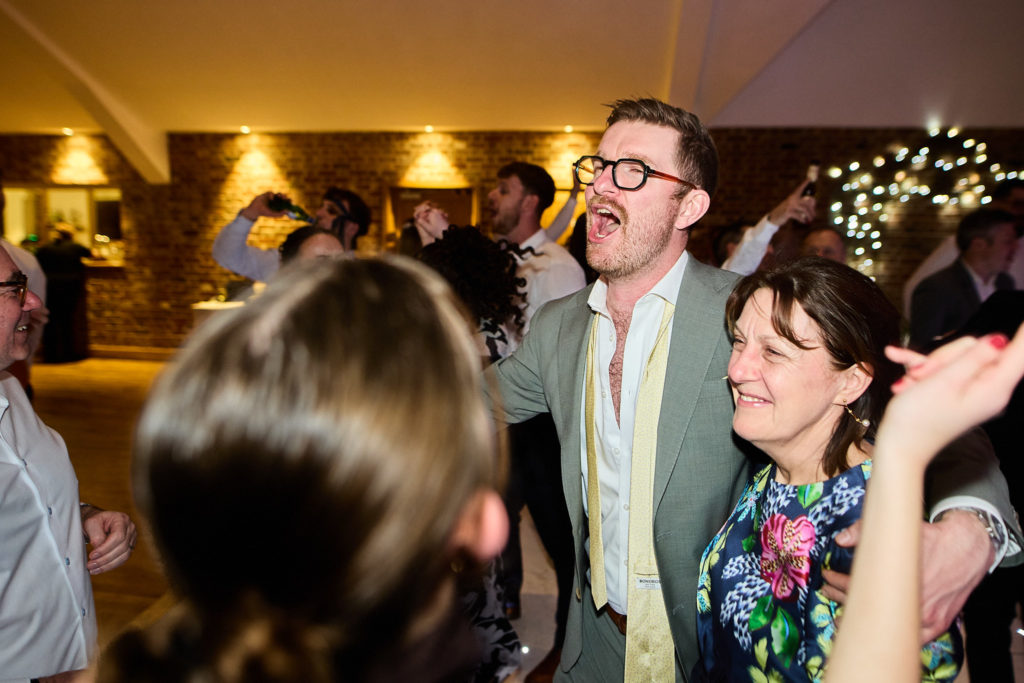 Wedding guests dancing and singing at the evening reception