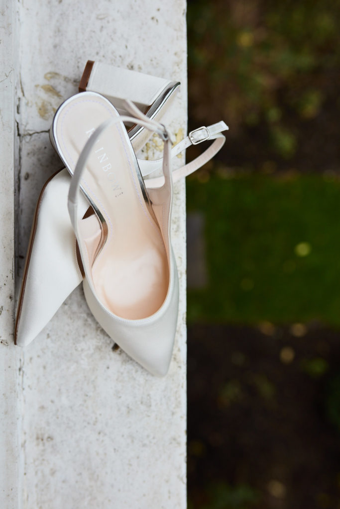 Ivory slingback bridal shoes on a stone ledge