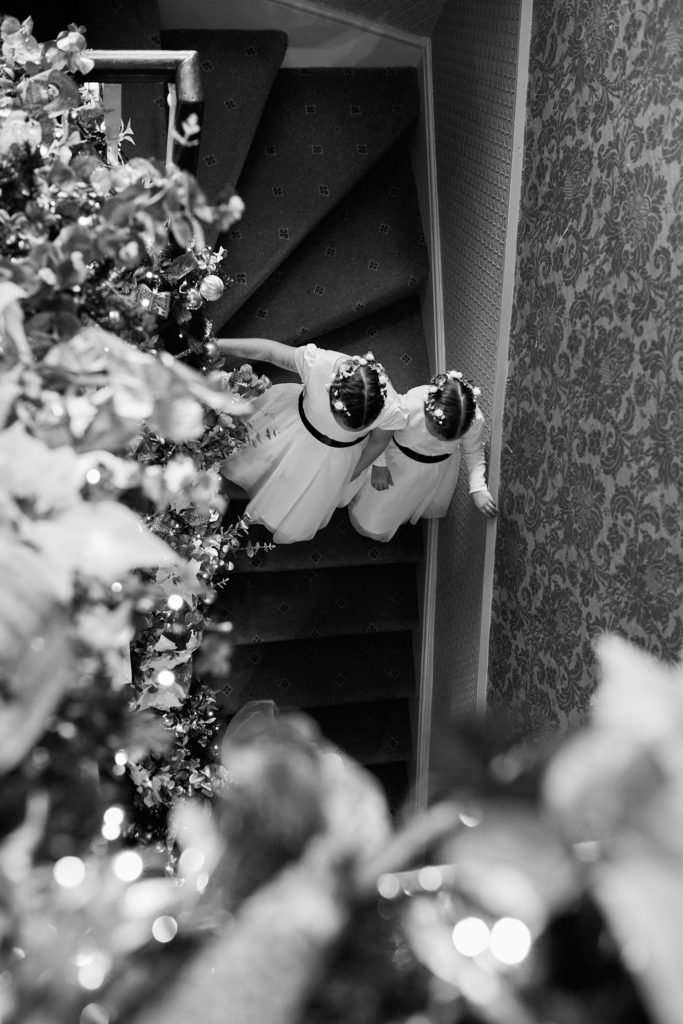 Black and white photo of bridal shoes on a staircase decorated with Christmas garlands