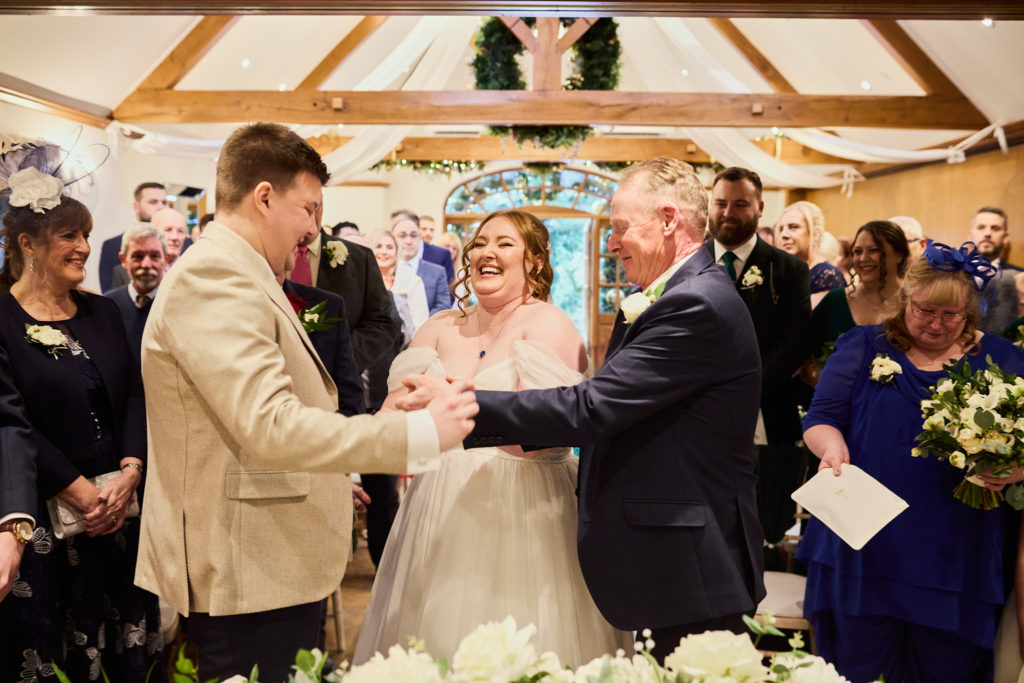 Groom shaking hands with the man who walked the bride down the aisle