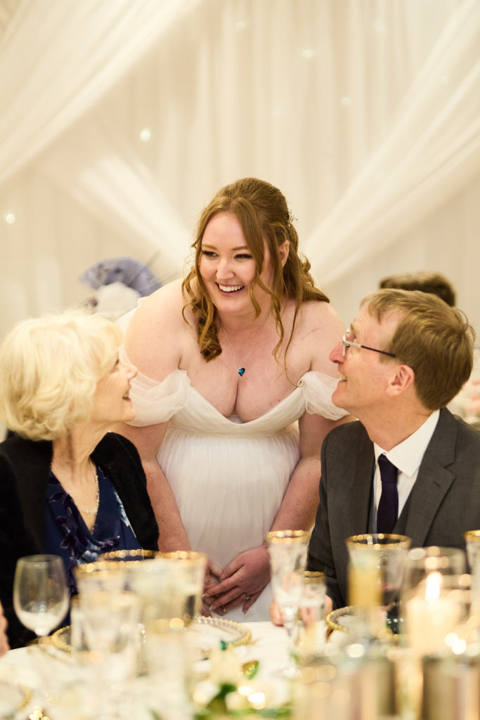 Bride laughing with guests at their table