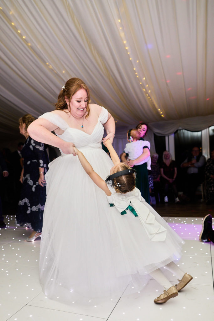 Bride dancing with two young bridesmaids on the dance floor