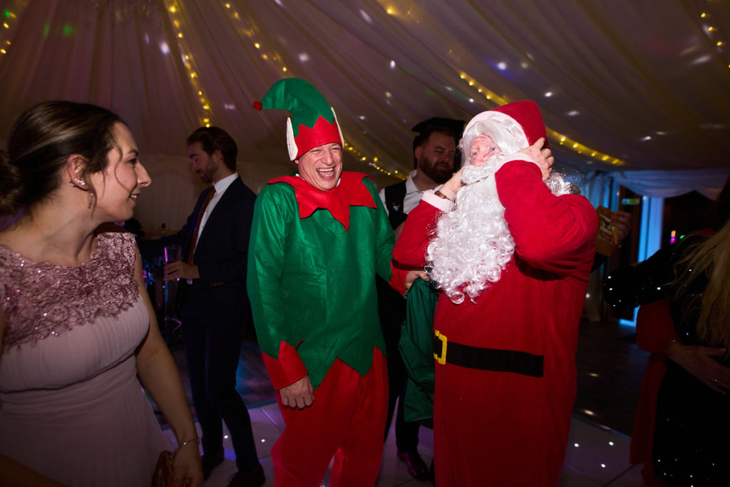 Guests dressed as Father Christmas and an elf on the dance floor