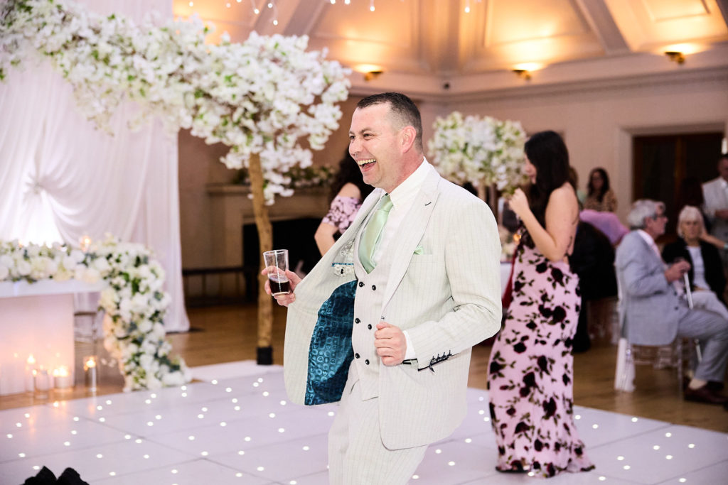 Groom laughing with guests beside the dance floor