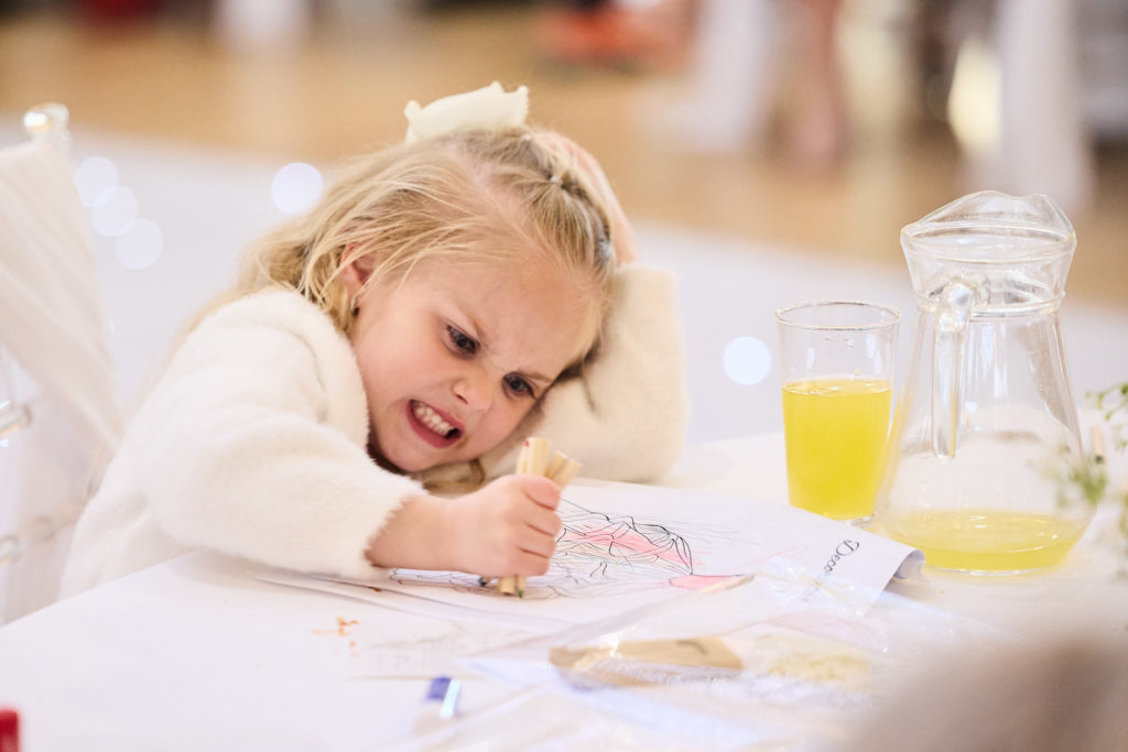 Flower girl colouring in at the table