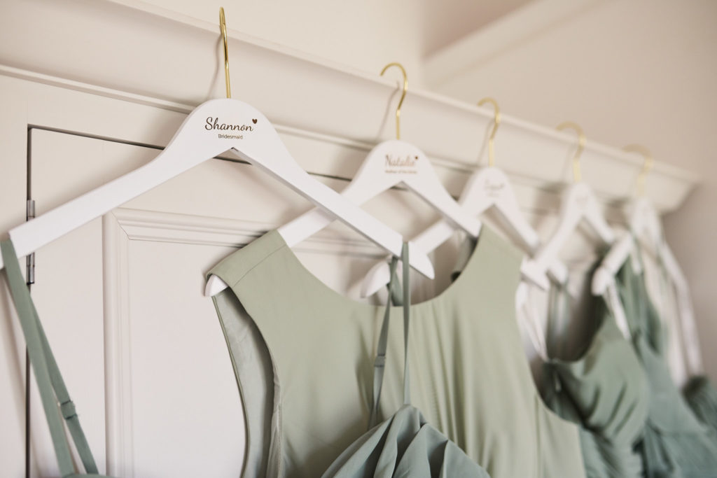 Sage green bridesmaid dresses on white personalised hangers