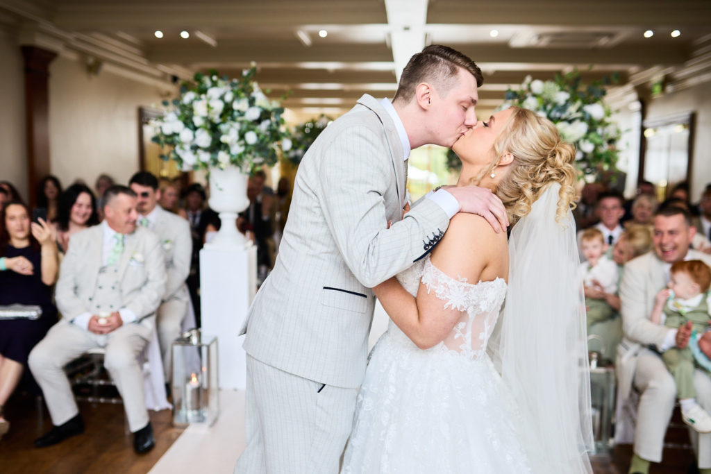 Bride and groom's first kiss in front of their guests at Stock Brook Manor
