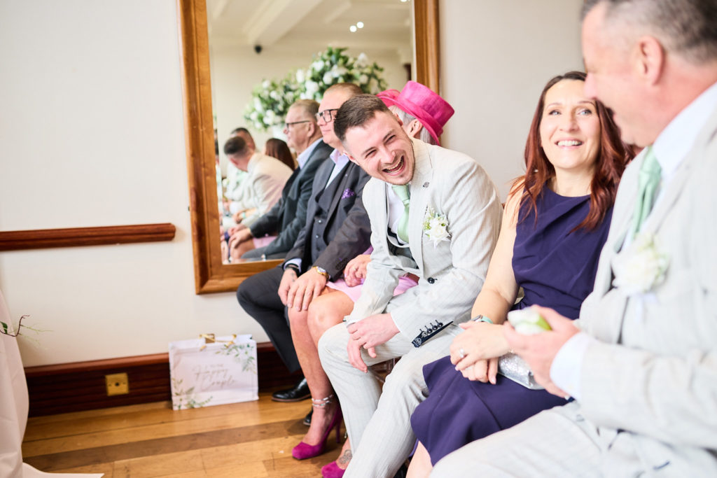 Wedding guests smiling as they watch the ceremony