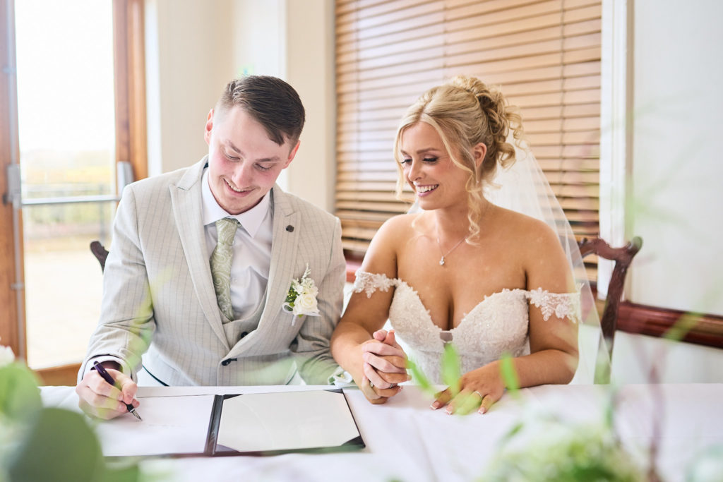 Bride and groom signing the register