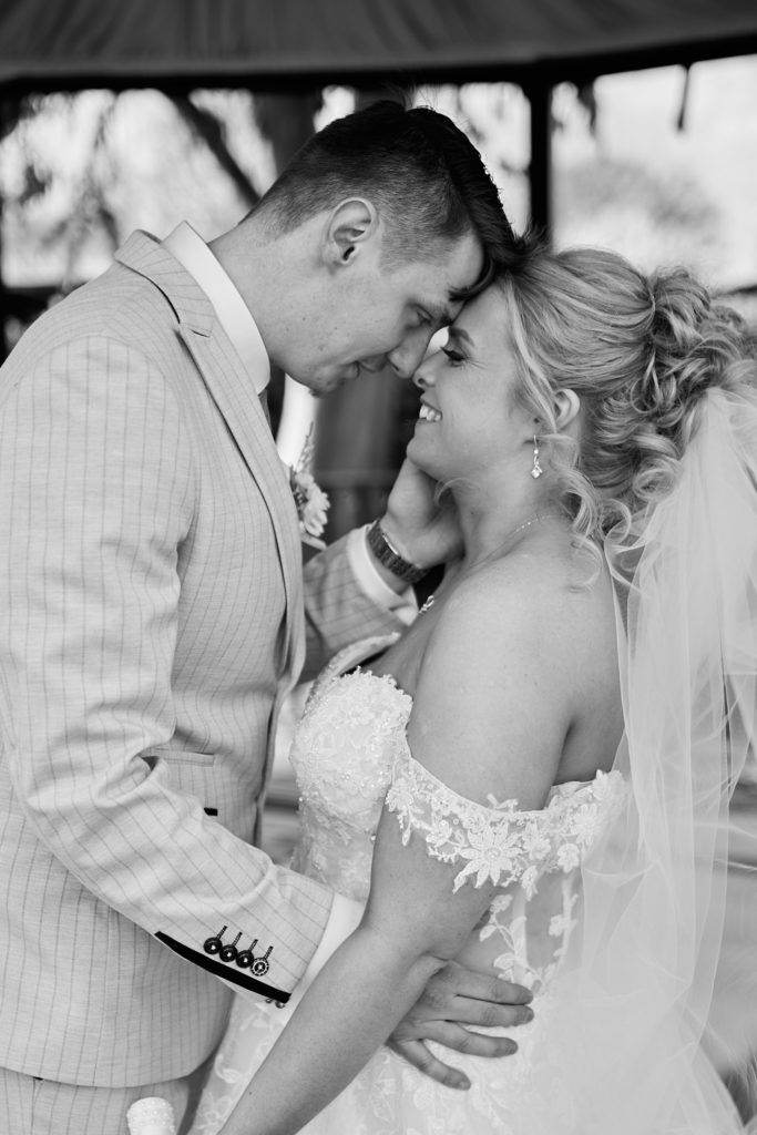 Black and white close-up of the bride and groom forehead to forehead