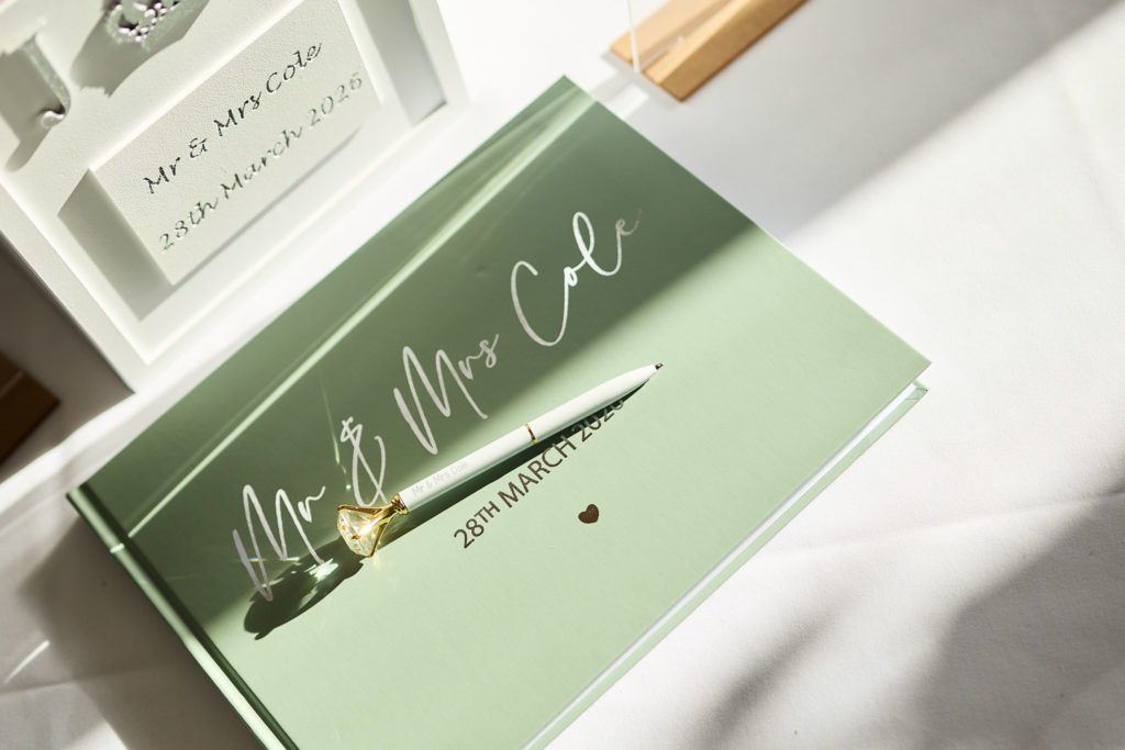 Sage green Mr and Mrs guest book with a pen