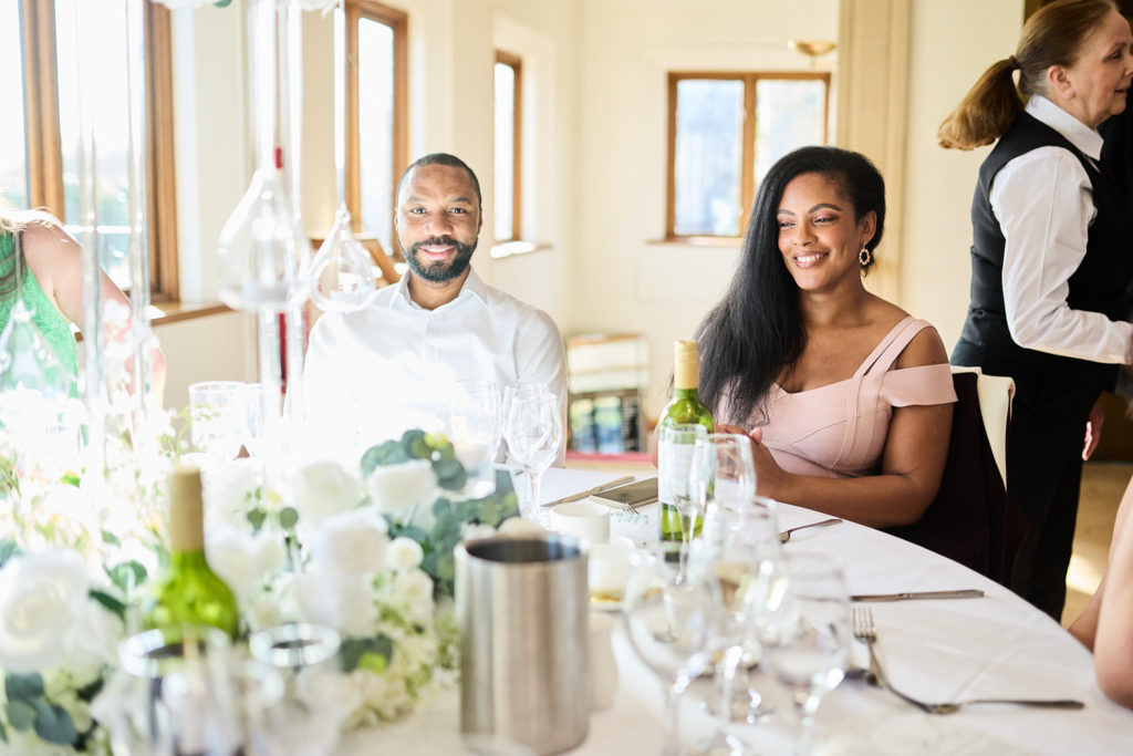 Wedding guests smiling at their table during the reception