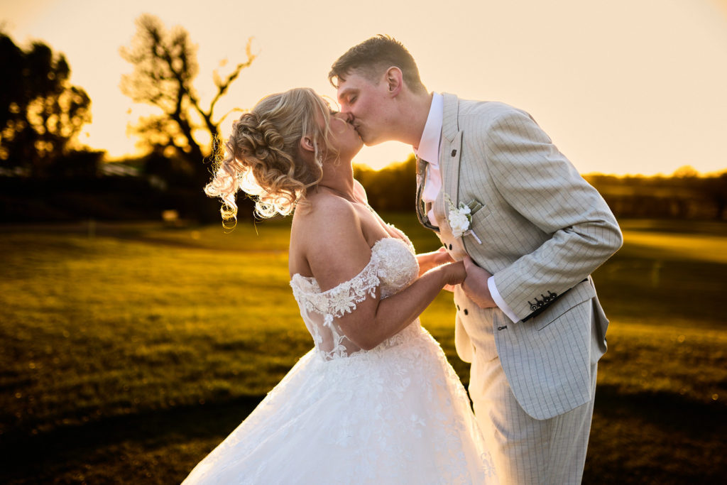 Bride and groom kissing at golden hour at Stock Brook Manor