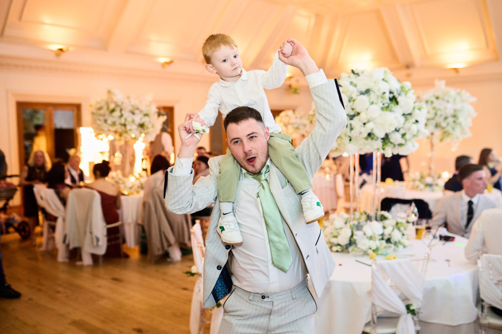 Man carrying a toddler on his shoulders at the reception