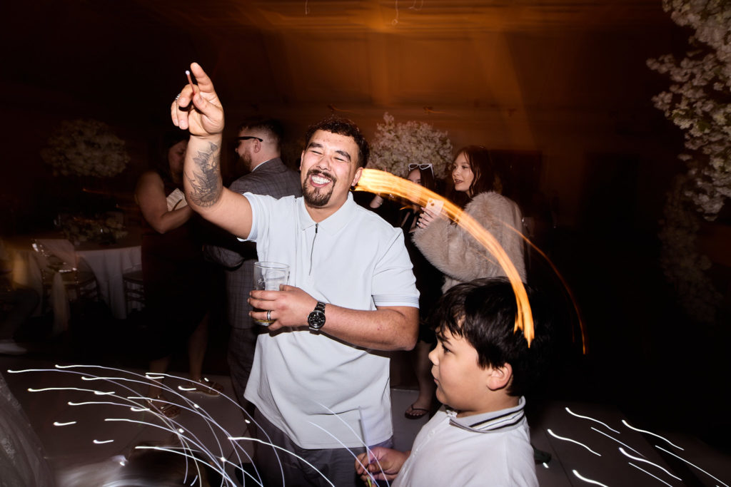 Man dancing with his arm in the air beside a boy