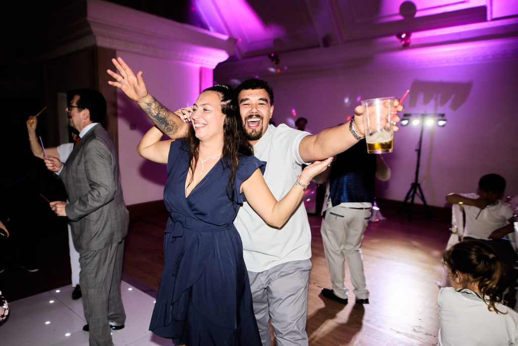 Wedding guests dancing under purple lights