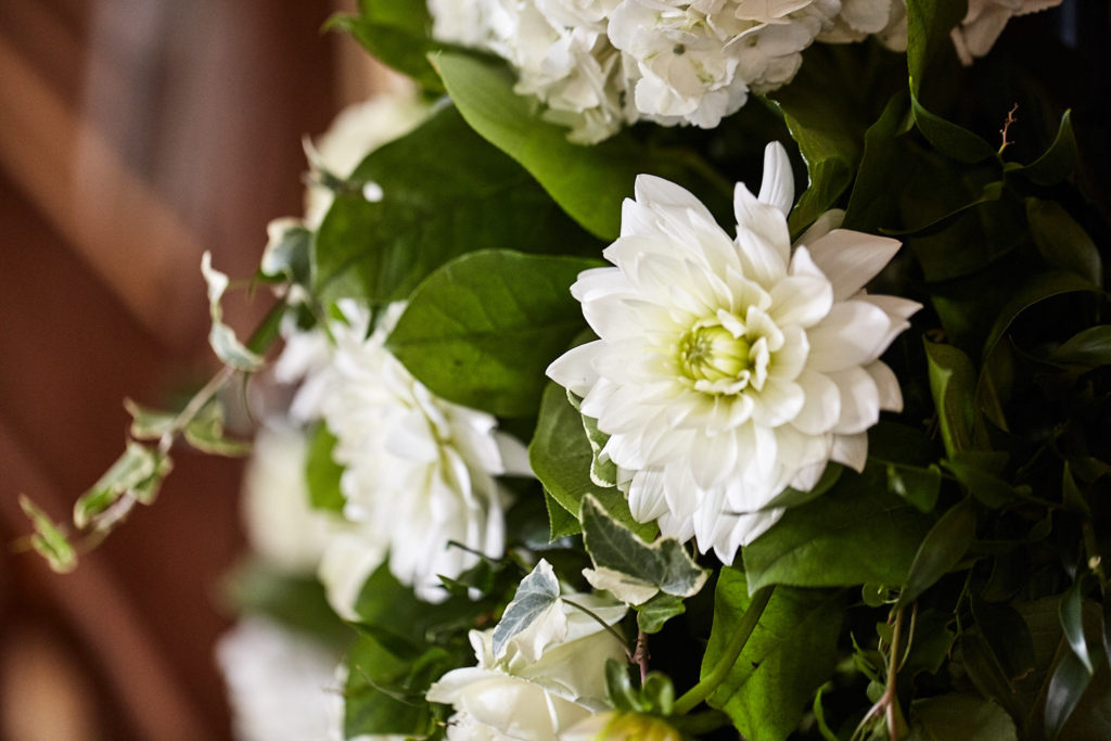 Close-up of white dahlias and foliage in the ceremony flowers