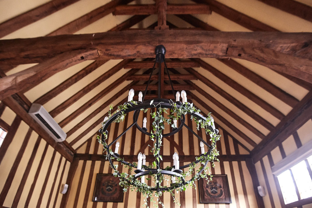 Iron chandelier wrapped in greenery beneath the oak-beamed roof at The Swan at Lavenham