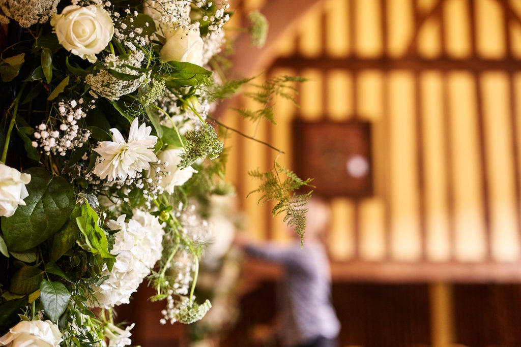 Florist arranging a garland of white flowers in the ceremony room
