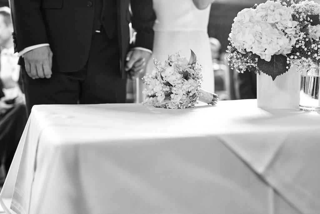 Black and white photo of the bride's bouquet on the registrar's table