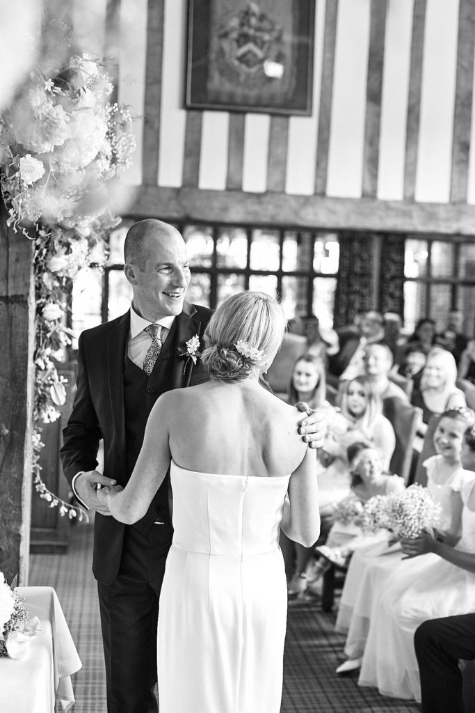Black and white photo of the bride and groom walking back down the aisle at The Swan at Lavenham