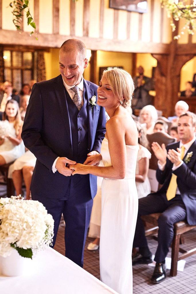 Bride and groom laughing as guests applaud at the end of the ceremony