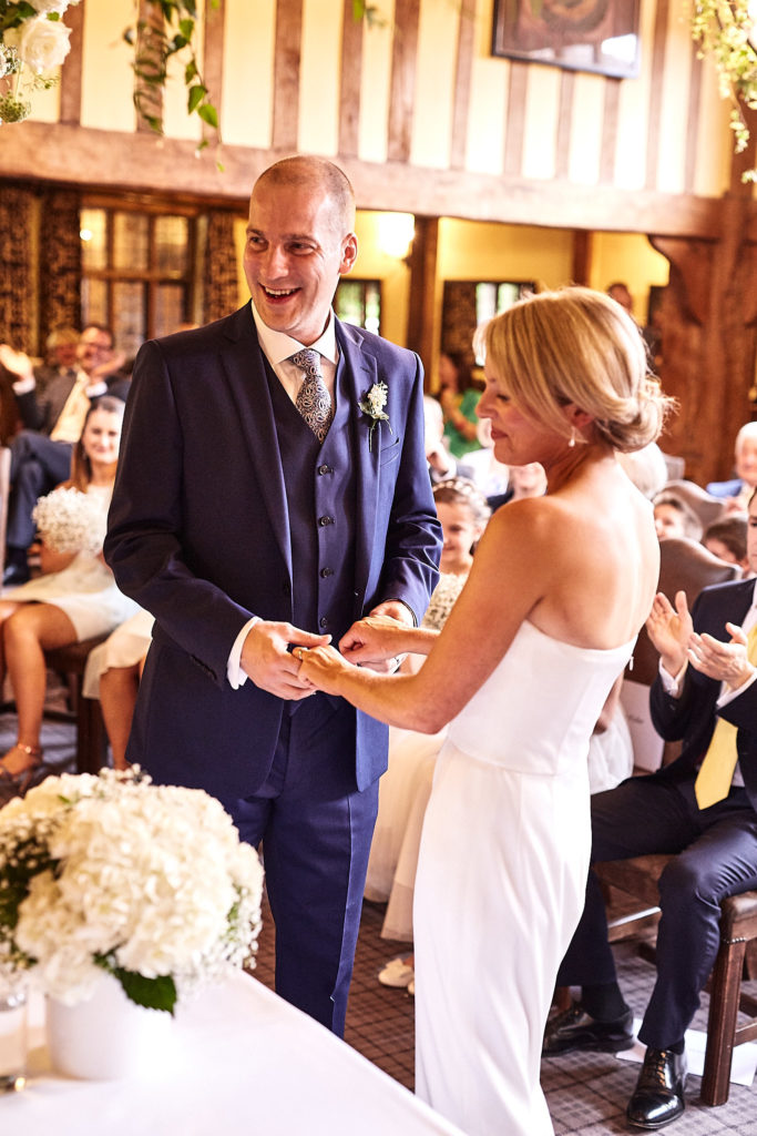 Bride and groom laughing together as their guests clap