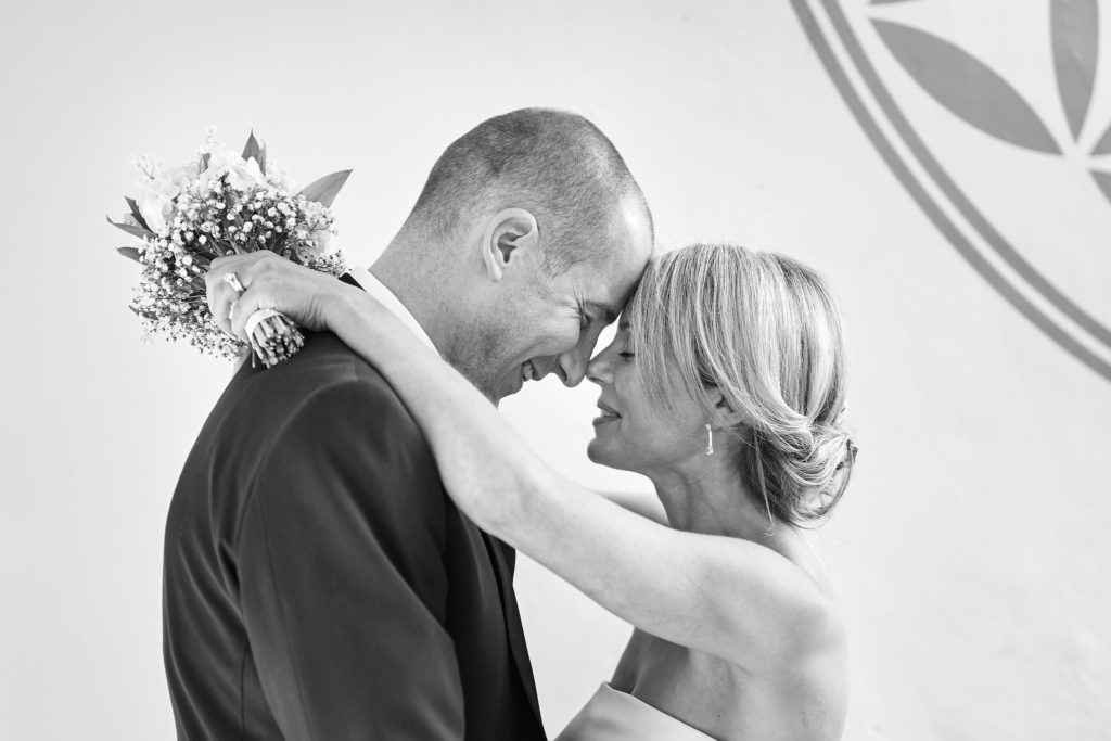 Black and white photo of the bride and groom embracing forehead to forehead