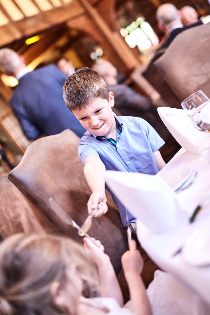 Young boy leaning across the table at the wedding breakfast