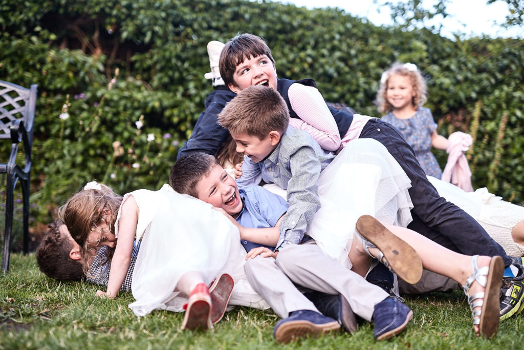 Children in a heap on the grass, laughing