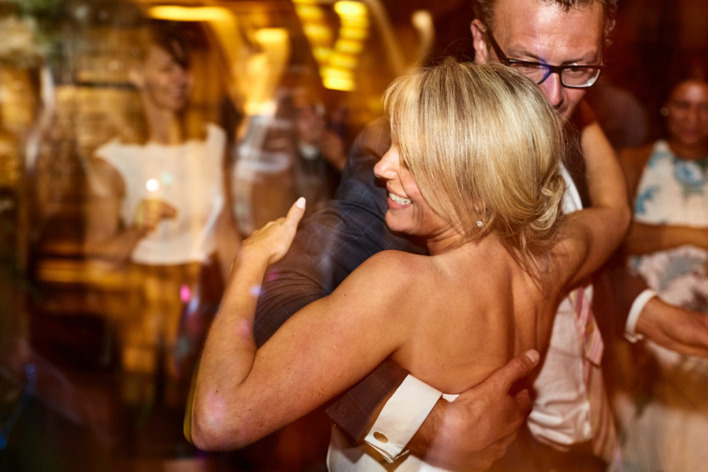 Bride dancing, seen from behind, in the timber-framed hall