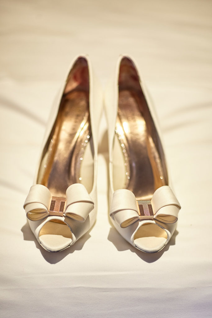 Pair of ivory bridal shoes with bows, seen from above