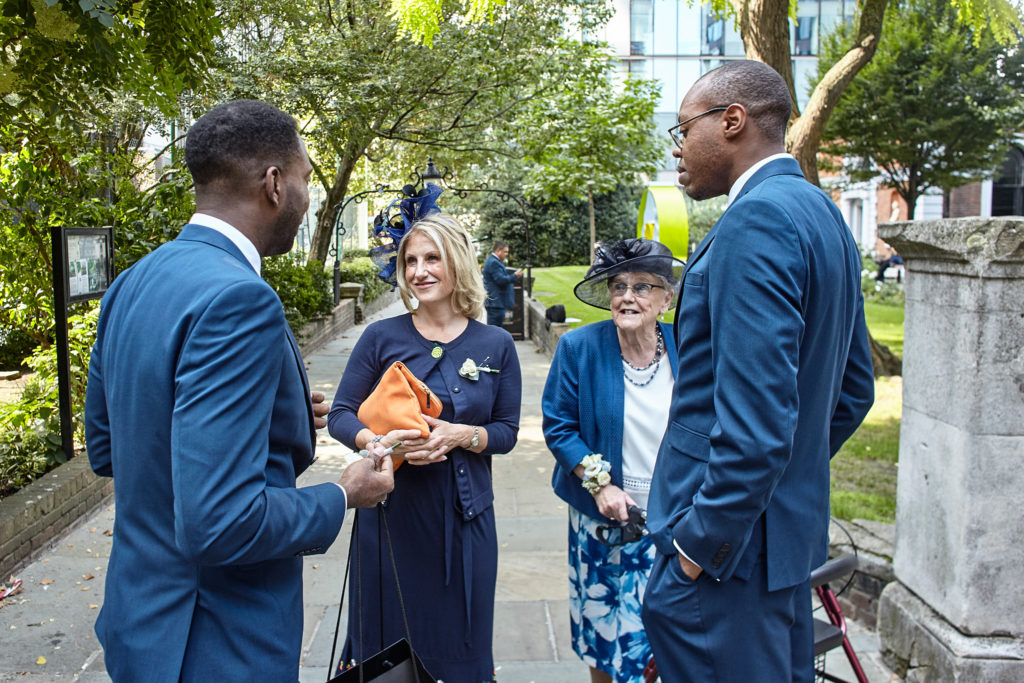 Groom and groomsmen chatting with guests outside the church