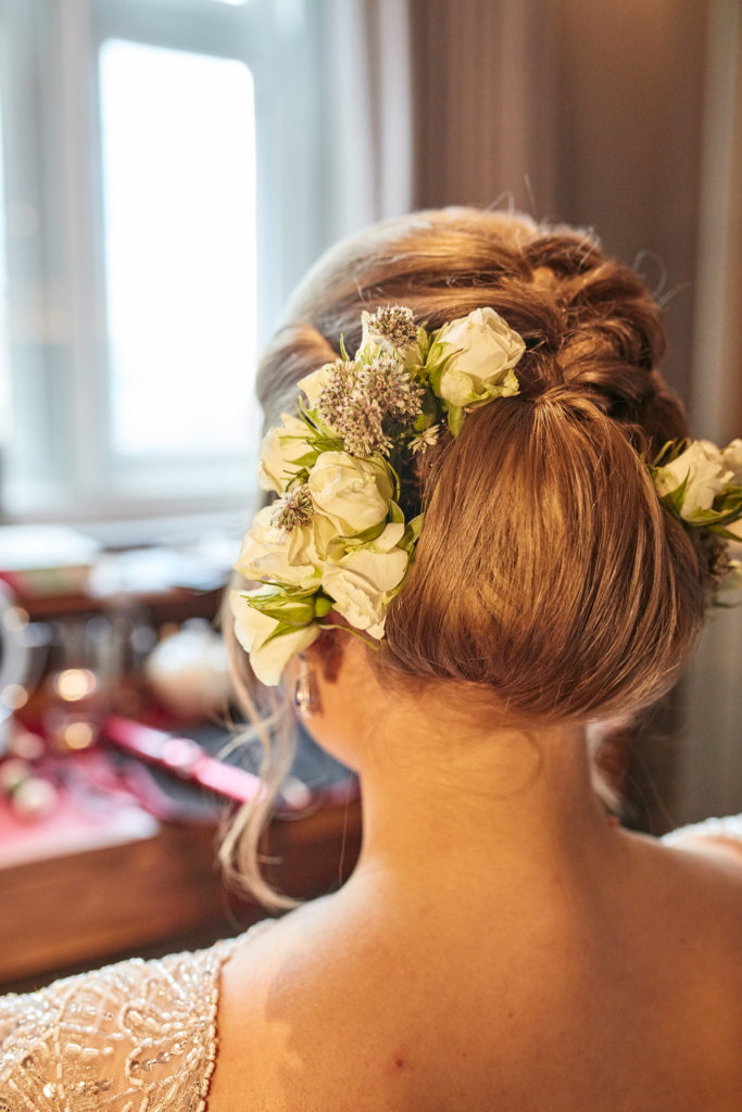 Back view of the bride's updo dressed with fresh flowers