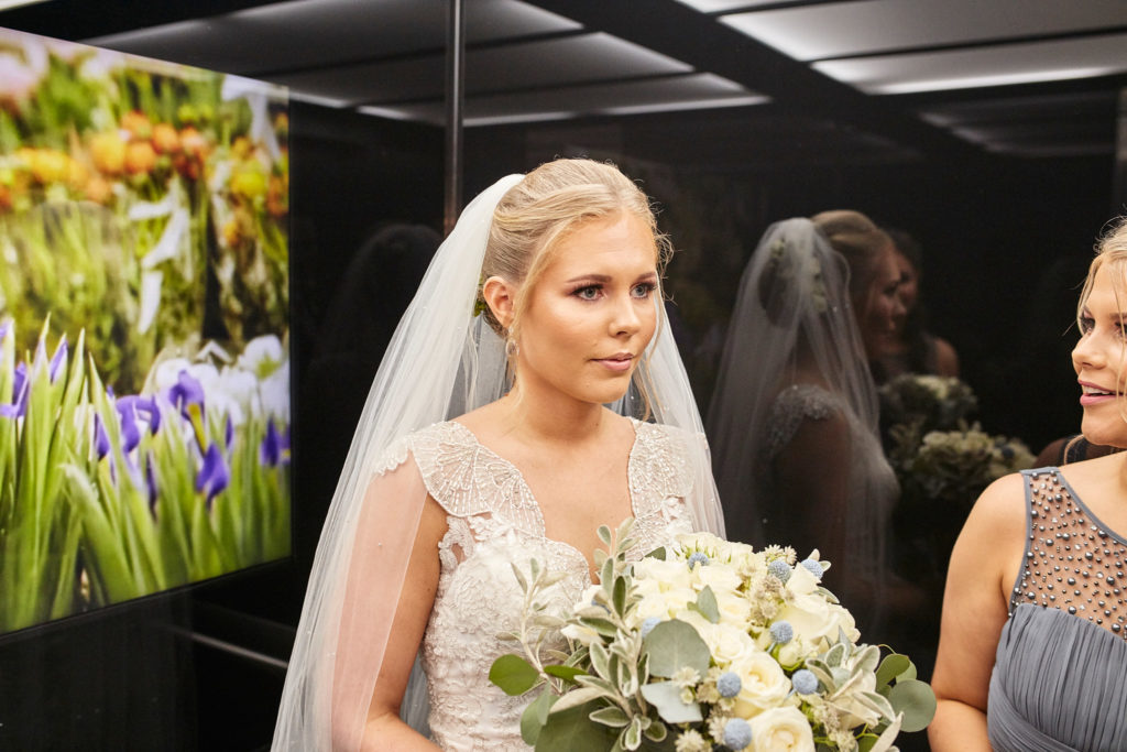 Bride in her veil holding her bouquet before the ceremony
