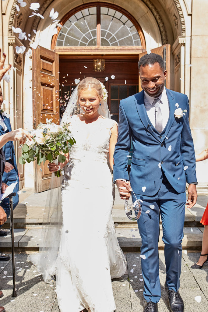 Bride and groom leaving the church through a shower of confetti