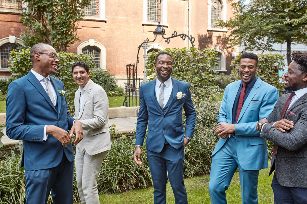 Groom laughing with his groomsmen in the garden