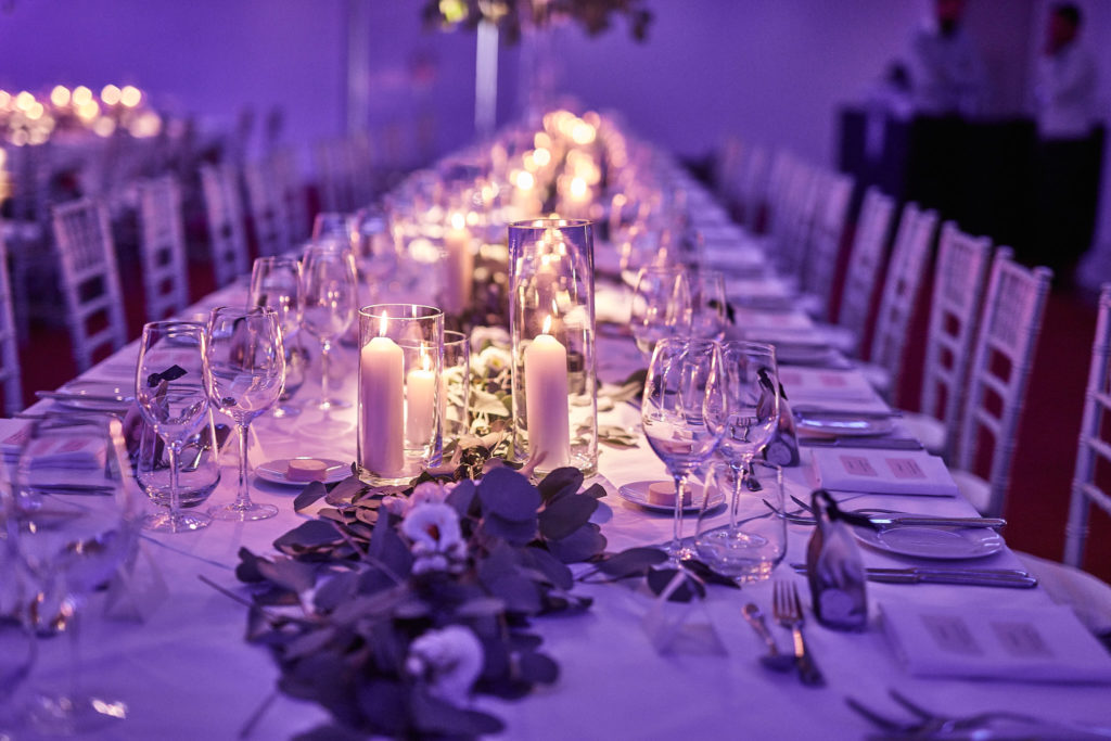 Long banquet tables lit in purple at the Andaz, London